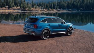 A blue 2027 Kia Sorento PHEV parked next to a stream